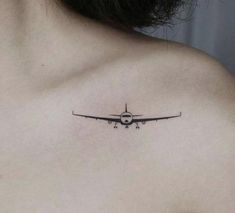 a small airplane tattoo on the back of a woman's upper arm and chest