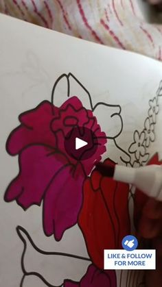 someone is drawing flowers on a piece of paper