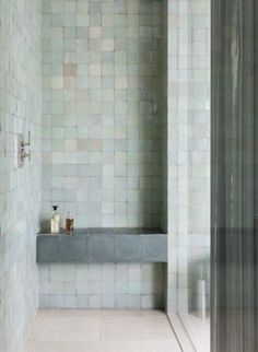 a bath room with a bench and tiled walls