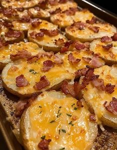 baked potatoes topped with bacon and cheese on a baking sheet