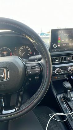 the interior of a car with dashboard, steering wheel and other electronic devices on display