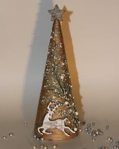 a small christmas tree with an ornament in the shape of a deer on it