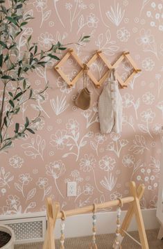 a baby's crib in front of a wall with flowers and plants on it