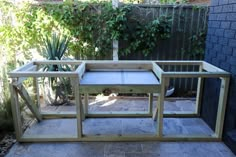 a wooden bench sitting in the middle of a yard next to a fence and plants