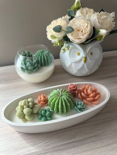 there are some fake succulents and flowers in the bowl on the table