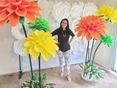 a woman standing in front of fake flowers