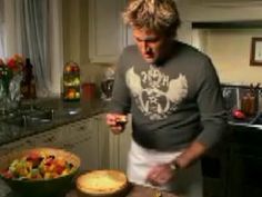 a man standing in front of a pie on top of a counter next to a bowl of fruit