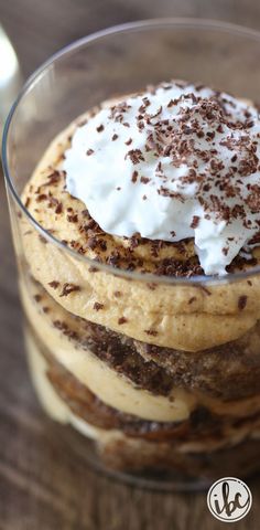 a dessert in a glass with whipped cream and chocolate shavings on the top