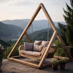 a wooden swing chair sitting on top of a wooden deck