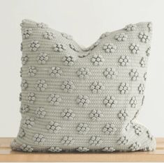 a gray pillow sitting on top of a wooden table