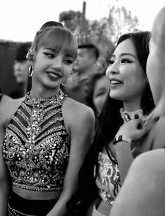 black and white photograph of two women in front of a group of people wearing headdress