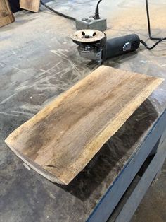 a piece of wood being sanded on top of a workbench with a grinder