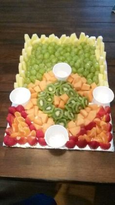 a platter filled with fruit and veggies on top of a wooden table