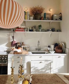 a kitchen filled with lots of counter top space and white cabinets next to a stove top oven