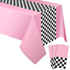 a pink table cloth with black and white checkered design on the top, along with matching napkins