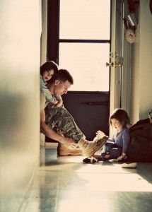 a man and two children sitting on the floor in front of a window with sunlight coming through