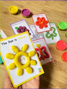 the sun is yellow book with matching cards and magnets in front of it on a wooden table