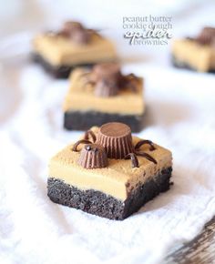 four pieces of cake sitting on top of a white towel with chocolate and peanut butter toppings