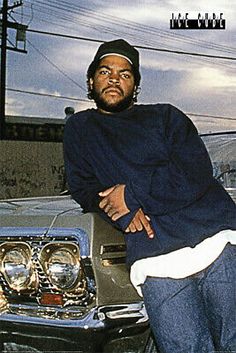 a man leaning on the hood of a car with his arms crossed in front of him