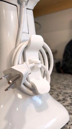 an electric device plugged into the side of a white object on a counter top