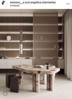 a table and two stools in a room with bookshelves on the wall