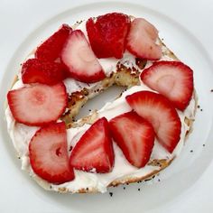 a white plate topped with a cake covered in strawberries