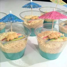 there are four cups with food in them and umbrellas sticking out of the top