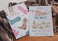 two cards with western themed designs on them sitting on a table next to some yarn