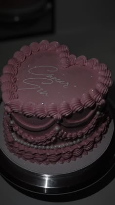 a heart shaped cake with the word love written on it, sitting on top of a table