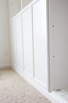 an empty room with white walls and carpet