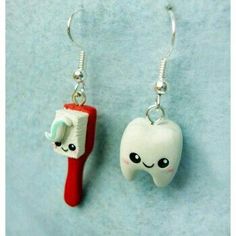 toothbrush and toothpaste earrings on blue background