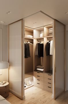 an open closet with clothes and shoes on the shelves, in front of a bed