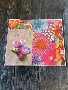 an orifu brooch is sitting on top of a wooden table next to a book