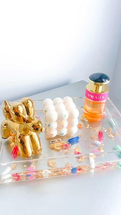 an acrylic tray with balloons, confetti and other items on it