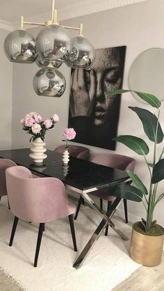 a dining room with pink chairs and a black table