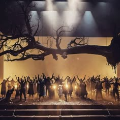 a group of people standing on top of a stage with their arms in the air