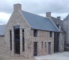 an old stone building with black doors and windows