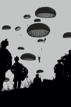 silhouettes of soldiers with parachutes flying in the sky