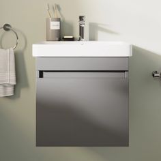 a bathroom sink sitting under a mirror next to a towel dispenser on a wall