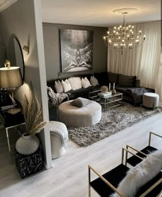 a living room filled with furniture and a chandelier hanging over the top of it