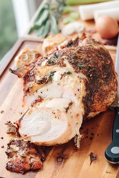 a large piece of meat sitting on top of a cutting board next to a knife