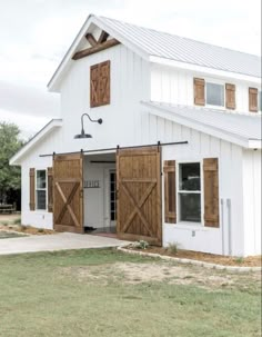 a white barn with wooden doors and windows