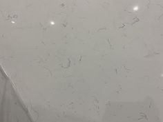 a white marble counter top in a bathroom with no shower curtain or door knobs