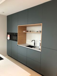 a kitchen with gray cabinets and white counter tops