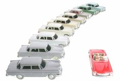 a row of toy cars sitting next to each other on top of a white surface