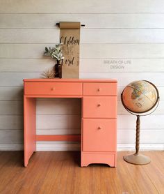 an orange desk sitting on top of a hard wood floor next to a wooden sign