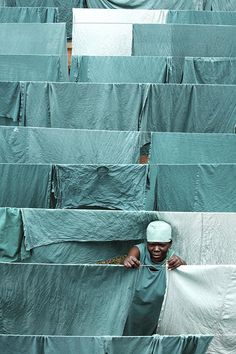 a person hiding behind some green tarp