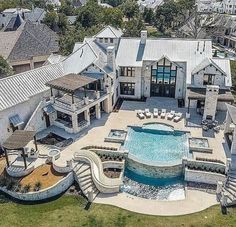 an aerial view of a large house with a pool in the middle and several lounge chairs around it