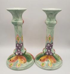 two green vases with colorful designs on them