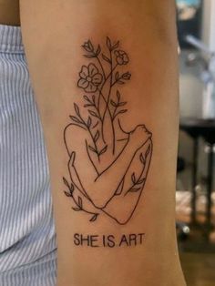 a woman's arm with a tattoo that says she is art and flowers on it